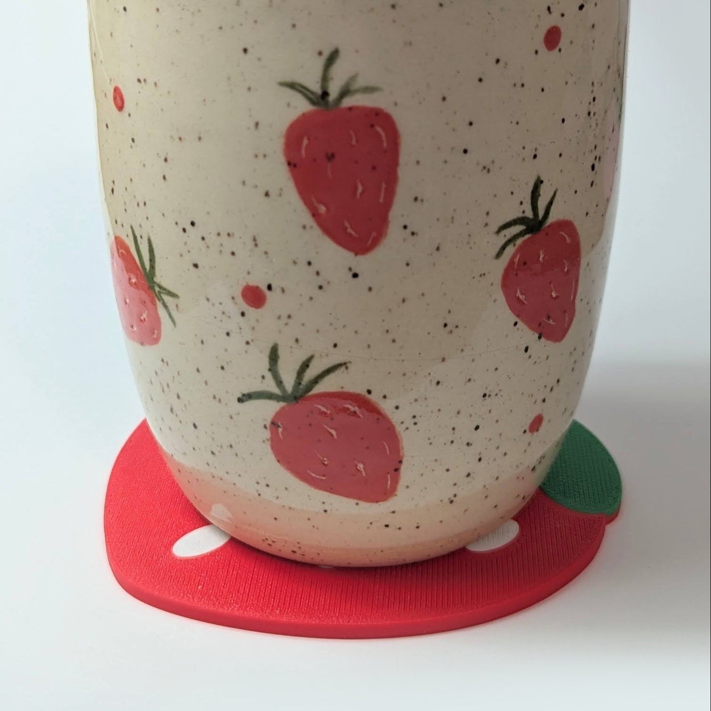 Ceramic cup with strawberry pattern on a white background